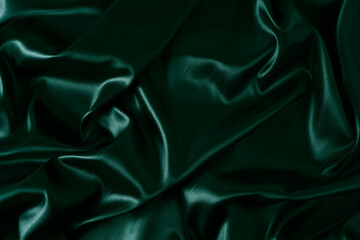 Silk fabric, abstract wavy green satin fabric background.