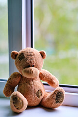 Bear childrens soft toy sitting edge an open window.Concept accidents with children.