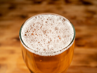 A glass of cold beer on a dark background. Glass of beer close-up.