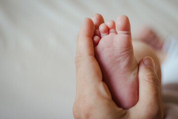 hand of mother holding foot of newborn
