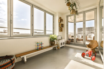 a living room with large windows and lots of plants in the window sies on either side of the room