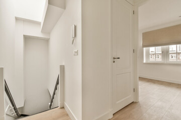 an empty room with white walls and wood flooring the door is open to let in light into the room