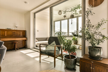 a living room with plants on the table and chairs in front of the glass door that leads to an outside patio
