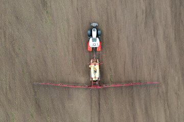 Top view of tractor spraying grain on a field.