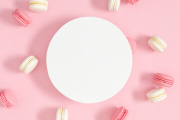 Colorful sweet french desserts.Vanilla and strawberry sweet french cookies. Cake macaroons or macaroon on pink background with round space for text, pastel colors. 