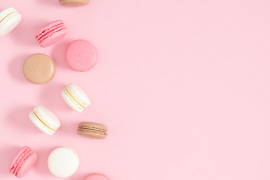 Colorful french desserts. Cake macaroons or macaroon on pink background, colorful almond cookies, pastel colors, macaroon for sweet break mock up. Flat lay, top view