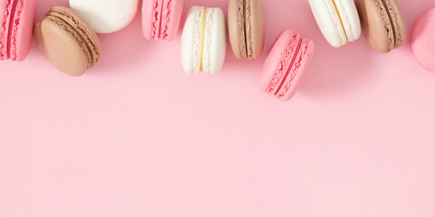 Colorful french desserts. Cake macaroons or macaroon on pink background, colorful almond cookies,...