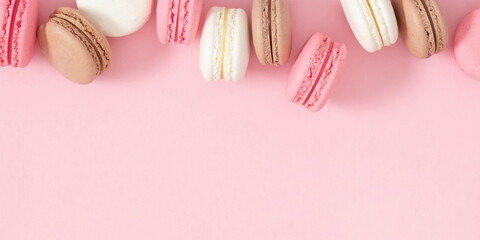 Colorful french desserts. Cake macaroons or macaroon on pink background, colorful almond cookies, pastel colors, macaroon for sweet break mock up. Flat lay, top view
