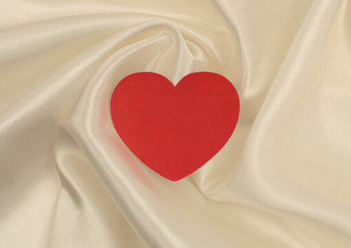 Beige white pearl wave silk fabric with heart frame card. Abstract texture horizontal copy space background.