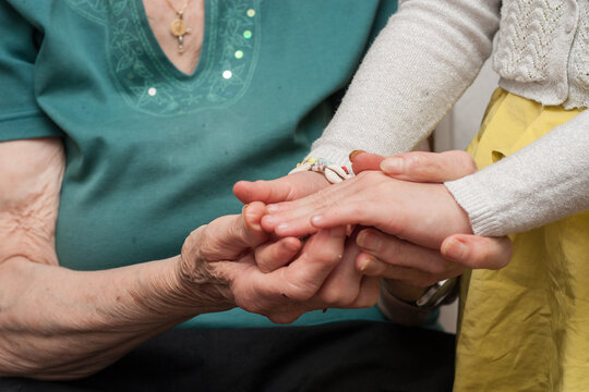 abuela y nieta dándose la mano