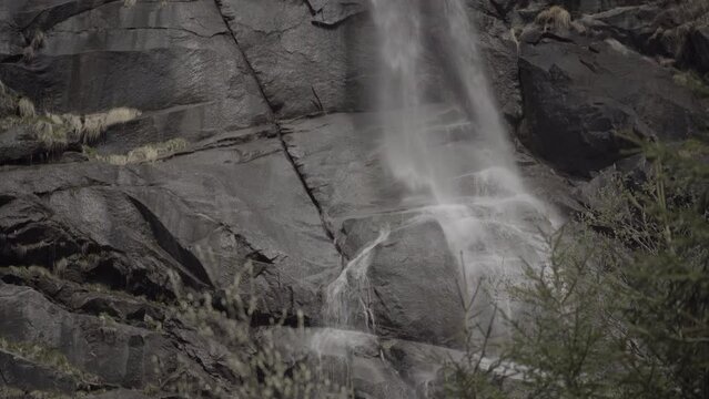 Dettagli delle Cascate Nardis nel parco Adamello-Brenta nella val di Genova in Trentino, Italia. Rocce scure e spruzzi d'acqua.
