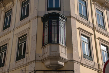 Fototapeta na wymiar Facade of an old house with red bay window, European historical buildings, Lisbon, Portugal