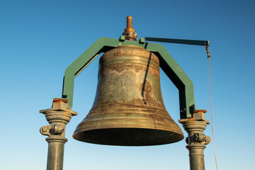 Fototapeta premium Big old bronze bell against the blue sky
