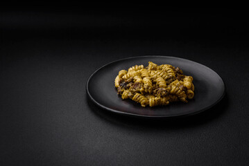 Obraz na płótnie Canvas Delicious fusilli pasta with green pesto sauce, with salt and spices