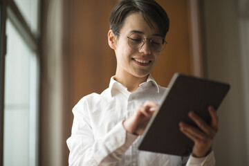 young business woman working in office, talking by phone, working with tablet, drinking coffee