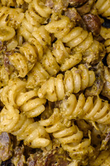 Delicious fusilli pasta with green pesto sauce, with salt and spices