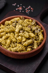 Delicious fusilli pasta with green pesto sauce, with salt and spices