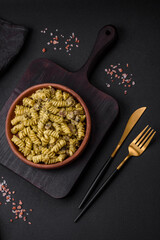 Delicious fusilli pasta with green pesto sauce, with salt and spices