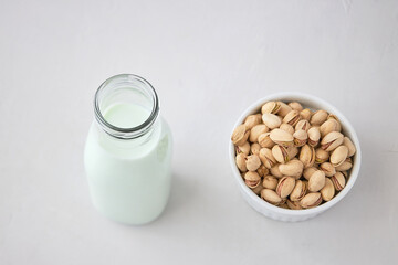 Homemade vegetable milk from pistachio nuts. Pistachio milk in a bottle on a gray concrete table. Ideal for vegans. place for text