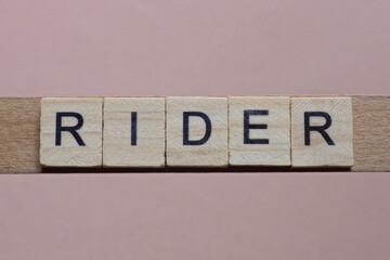 gray word rider made of wooden square letters on brown background