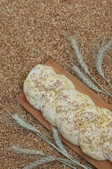 Raw bun, dough with sesame seeds, with black cumin seeds, wheat, grain, ears of corn, background, background image for presentations