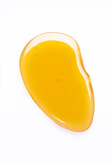 Beautiful drop of honey or other yellow liquid isolated on white background. Yellow or orange drop of oil on a light background
