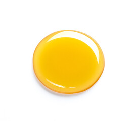 Beautiful drop of honey or other yellow liquid isolated on white background. Yellow or orange drop of oil on a light background
