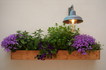 hanging wooden pot of mixed flowers and herbs
