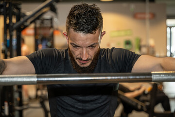 homme en pause entre deux squat avec poids dans une salle de musculation
