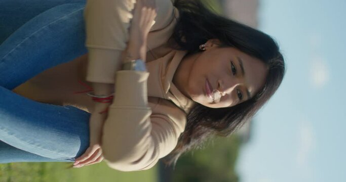 Close-up young sad Latina college student teen in a park, vertical shot