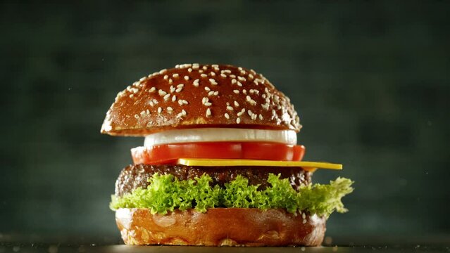 Super slow motion of stacking cheeseburger pieces. Camera in motion. Filmed on high speed cinema camera, 1000 fps. Placed on high speed cine bot. Speed ramp effect.