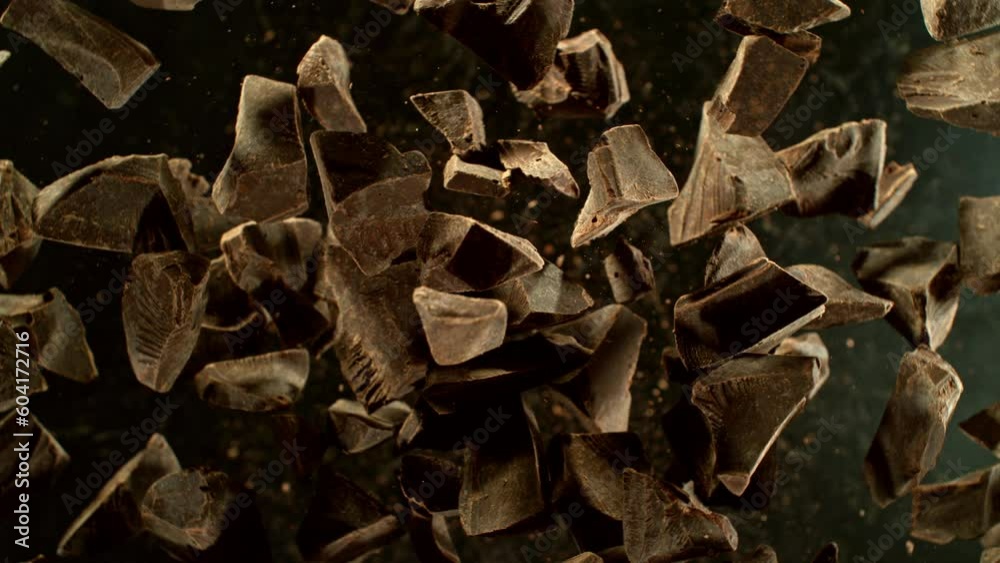 Poster super slow motion of rotating group of raw chocolate pieces. super fast camera motion. filmed on hig