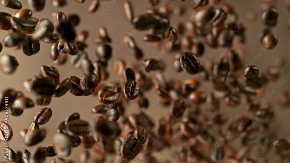 Poster Super slow motion of rotating coffee beans on black background. Filmed on high speed cinema camera, 1000 fps placed on high speed cine bot.  Camera moving up with rotation. Speed ramp effect.