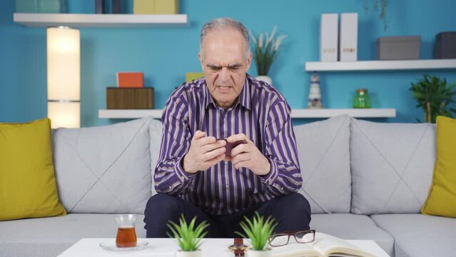 Aggressive and grumpy old man is using phone.