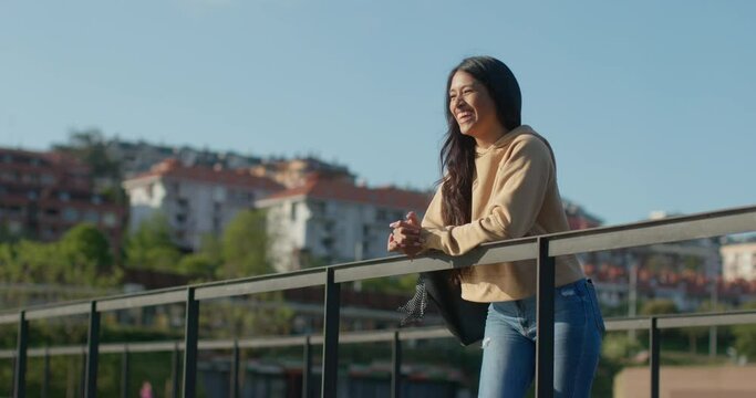 Young teenage latin college student using social networks with her smartphone in a park