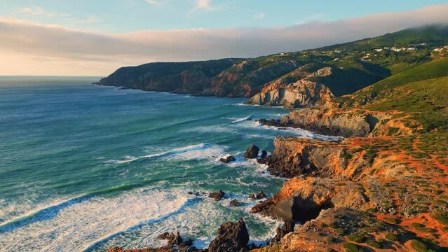 Turquoise ocean greenery hills landscape aerial. Waves rolling rocky coastline