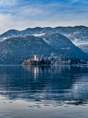 Assumption of Maria Church island in the middle of lake bled and snow the mountain during winter, Slovenia