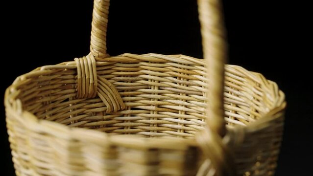 Fragment of a basket made of willow twigs or garden furniture. On black background