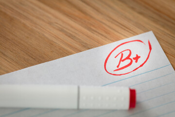 Good grade of B plus (B+) is written with red pen on the test.
