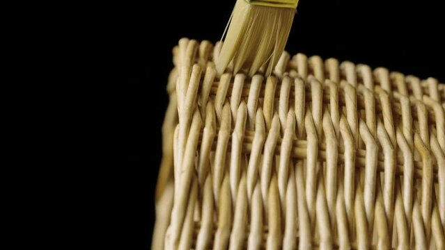 Fragment of a basket made of willow twigs or garden furniture. On black background