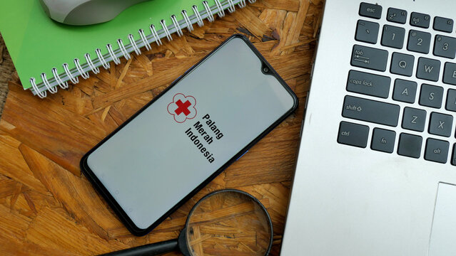 Bekasi, Indonesia - April 2,2022: PMI or palang merah indonesia on smartphone, popular charity organization in Indonesia