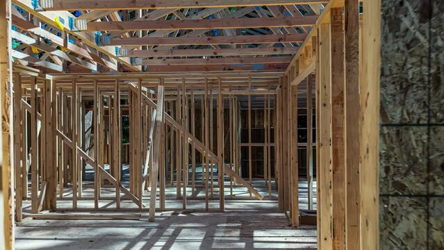 Zooming away from a new construction home, transforming from a bare frame structure to a completed home