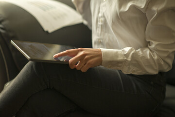 young businesswoman working with laptop and tablet in office, talking on phone and evaluating work