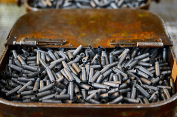 Metal containers full of bullet casings on table at plant