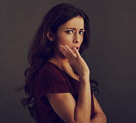 Beautiful hmor grimacing unhappy shock brunette business woman looking with open mouth covering the hand and big eyes on grey background with empty copy space. Closeup