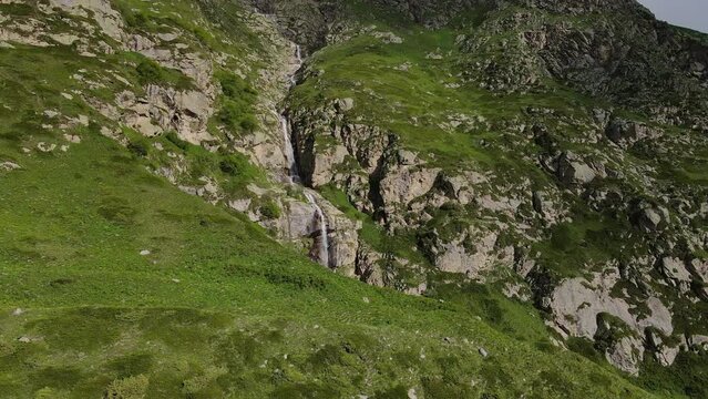 Aerial view of a waterfall flowing down the slope of a gorge in the mountains
