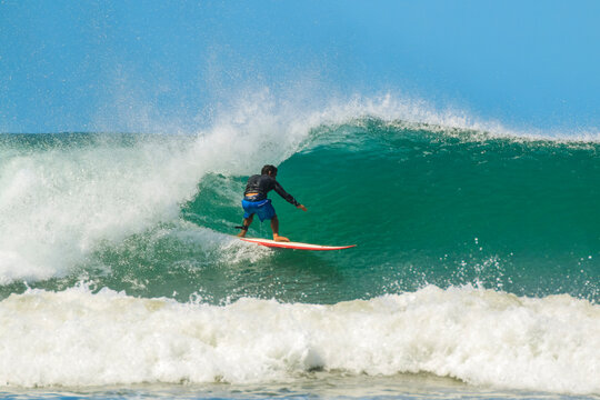 Shortboard surfer rides a wave at this fast-growing surf beach and yoga destination, Playa Guiones, Nosara, Guanacaste, Costa Rica
