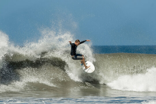 Shortboard surfer rides a wave at this fast-growing surf beach and yoga destination, Playa Guiones, Nosara, Guanacaste, Costa Rica