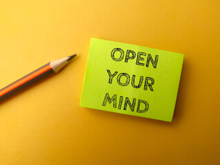 Sticky note and pencil with the word OPEN YOUR MIND