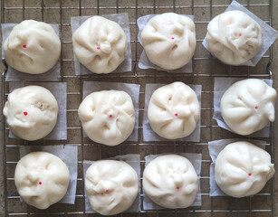 top view of group of Steamed Buns laying on stainless tray at food industry factory, pre-cook food business.